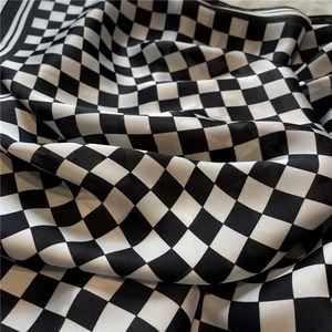 Macro shot of checkerboard silk scarf texture with elegant drapes and glossy finish