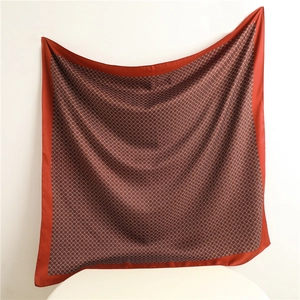 Detail of red and orange geometric silk scarf with glossy finish and solid border