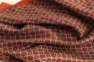 Detailed macro view of retro floral print fabric with elegant silk texture and drape