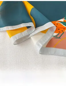 Détail de foulard en soie à motif d'oiseaux montrant l'ourlet roulé et l'imprimé abstrait