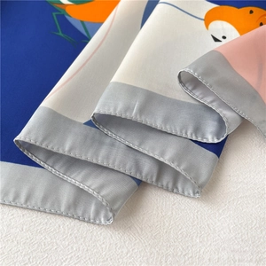 Gros plan d'un foulard en soie aux motifs d'oiseaux colorés avec bordure roulée de luxe
