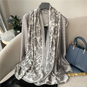 Detail showing elegant paisley and houndstooth pattern on a long satin silk scarf