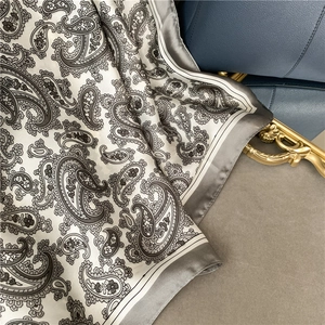 Close-up of retro paisley pattern scarf with silky texture and elegant grey border detail