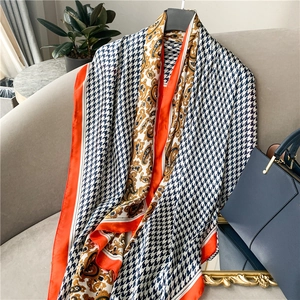 Detailed macro of vintage paisley and houndstooth patterns on a silky long scarf shawl