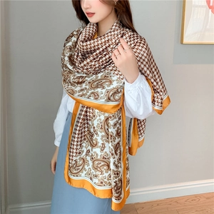 Detail of silk-like scarf featuring brown houndstooth and vintage paisley拼接 patterns