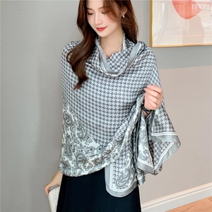Elegant houndstooth and paisley silk-feel long scarf worn by a model in soft lighting