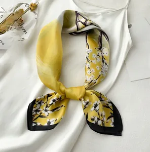 Detail of elegant 70cm silk-like yellow scarf with black and white floral pattern