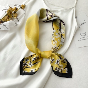 Elegant yellow floral silk scarf with small white flowers and a stylish black border