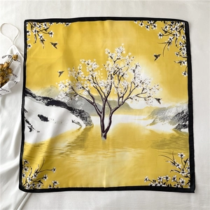 Detail of a square silk scarf with yellow bird and floral landscape pattern