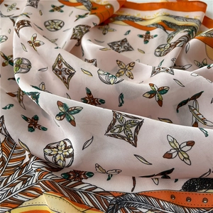 Pink silk-feel scarf with geometric patterns and bright orange borders for women