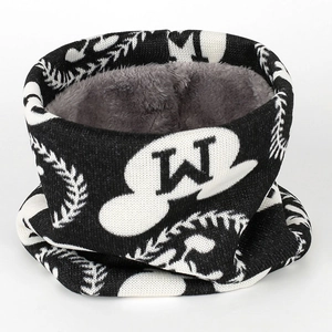 Détail du cache-col en tricot avec motif 'W' noir et blanc et doublure polaire grise épaisse