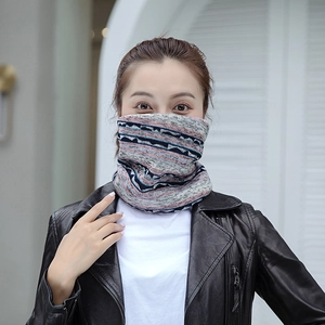Détail d'un tour de cou en tricot d'hiver aux motifs géométriques gris, bleu, rouge