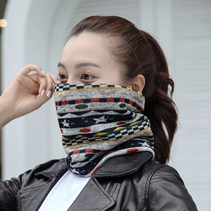 Détail d'un cache-col en tricot d'hiver avec motifs géométriques colorés et étoiles
