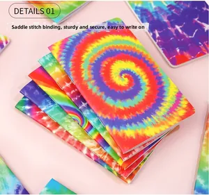 Detailed view of tie-dye mini notebooks showing saddle stitch binding and rainbow covers