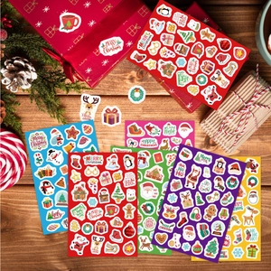 Set de stickers de Noël avec Père Noël et rennes sur un bureau en bois rustique