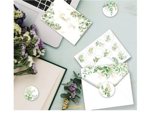 Detail of eucalyptus thank you cards with envelopes and botanical seal stickers on a desk