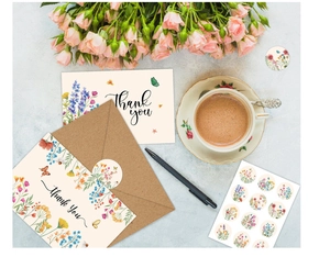 Floral thank you card with kraft envelope and seal sticker next to pink roses