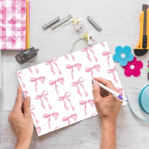 Flat lay of pink watercolor bow decorative paper with DIY handicraft tools on wood table
