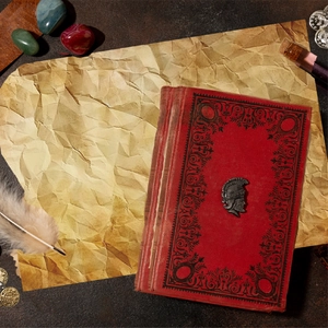 Detailed close-up of Spartan helmet brooch on vintage book with antique parchment