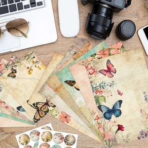Vintage floral and butterfly letter stationery set displayed on a wooden desk with a camera