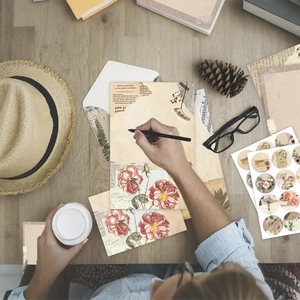 Vintage floral stationery set with letter paper and stickers on a rustic wooden desk