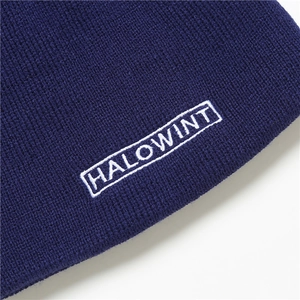 Detail of HALOWINT embroidery on a navy blue knit beanie with fine texture