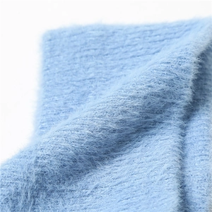 Detailed close-up of soft light blue mohair knit fabric showing fluffy texture