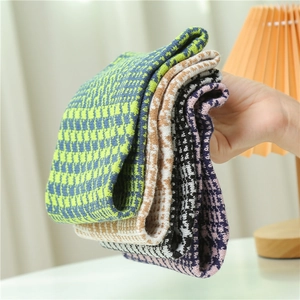 Detail of four colorful houndstooth and checkerboard knitted neck warmers in thick fabric