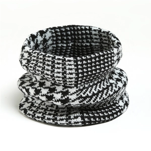 Detailed view of the thick black and white houndstooth knit texture on this winter neck gaiter