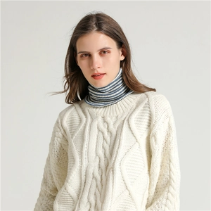 Close-up of cream cable knit texture with striped turtleneck design on sweater