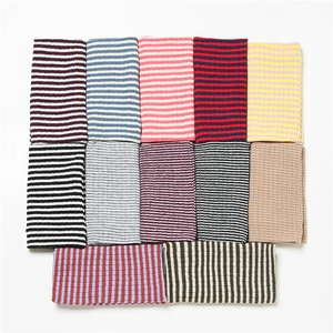 Detail view of various colorful striped knit patterns showing fine ribbed texture for scarves