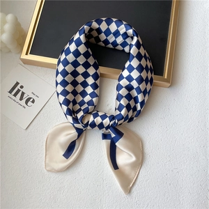 Élégant foulard en satin à carreaux bleu et blanc présenté avec un décor de luxe