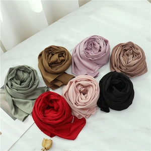 Solid color long hijabs in 7 diverse tones arranged in rose shapes on marble