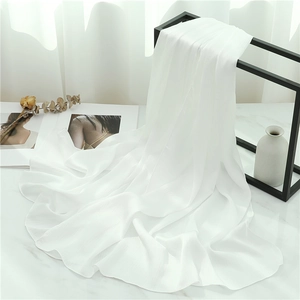 Detail of white pleated chiffon scarf showing soft texture and fine organza fabric drape