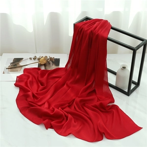 Detailed view of dark red pleated chiffon scarf draped on a geometric metal rack