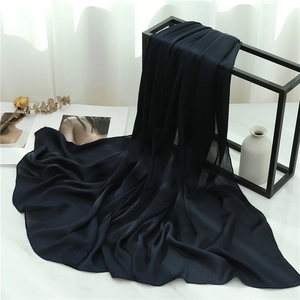 Detail of navy blue pleated scarf showing light breathable fabric texture on a stand