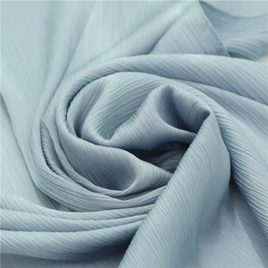 Macro shot of pleated light blue chiffon fabric with vertical texture and soft drape