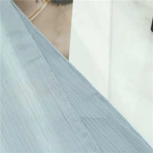 Detailed macro view of light blue crinkle fabric texture for scarves and shawls