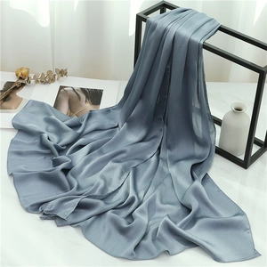 Detail view of smog blue scarf fabric with fine pleated texture on a modern rack