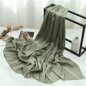 Sage green pleated scarf detail showing vertical crinkle texture on elegant display