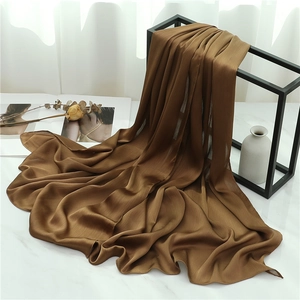 Close-up of caramel crinkle texture scarf draped elegantly over a black metal frame