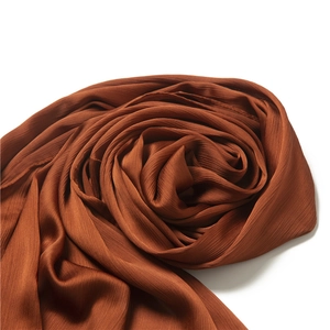 Detailed macro view of the rust-brown lightweight fabric texture and soft sheen