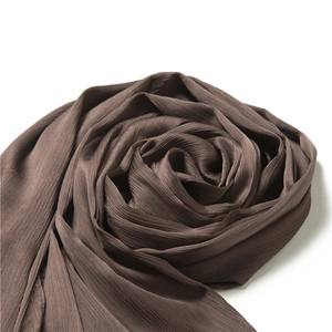 Detailed texture of dark brown pleated long scarf with elegant rose fold arrangement