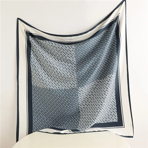 Detail of navy blue and beige silk square scarf featuring vintage chain monogram pattern