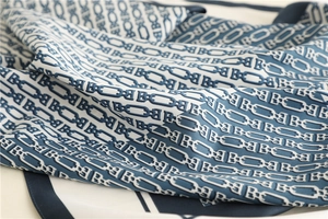 Close-up of silk square scarf showing luxury chain pattern and smooth satin texture