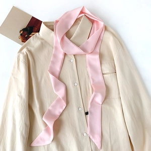 Elegant pink silk skinny scarf styled on a beige shirt for a soft feminine look
