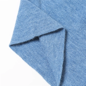 Gros plan sur le tissu en maille bleue montrant la texture douce et le motif de tissage