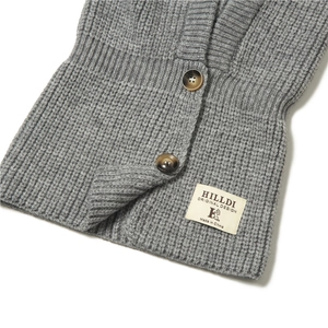 Dettaglio del passamontagna grigio in maglia a coste con bottoni tartarugati e logo