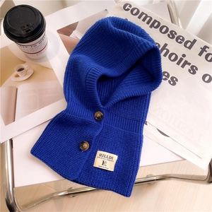 Dettaglio di passamontagna in maglia blu reale con bottoni marroni e patch