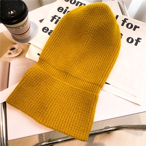 Passamontagna giallo in maglia con scaldacollo a coste calde su superficie bianca